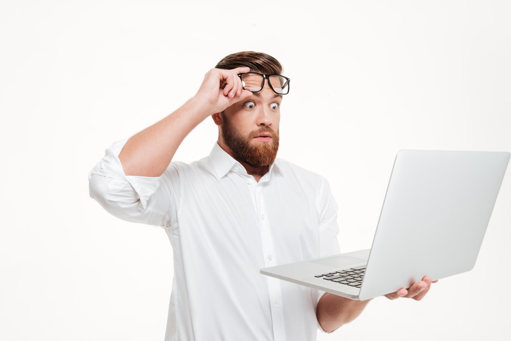 surprized white male looking into his computer on a white background
